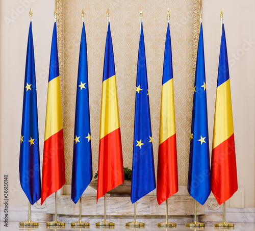 Romanian and European Union flags one next to another inside a hall