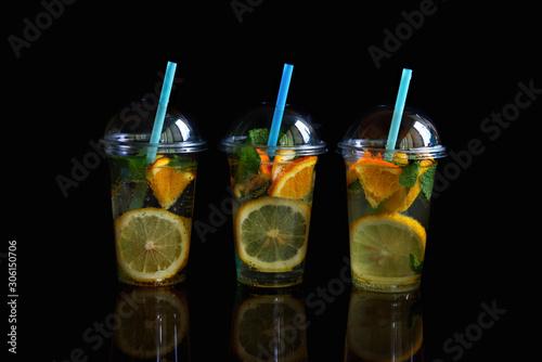 Three glasses of lemonade isolated on a black background.