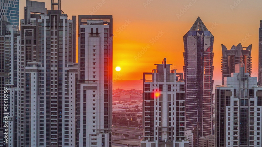 Modern residential and office complex with many towers aerial timelapse at sunset in Business Bay, Dubai, UAE.