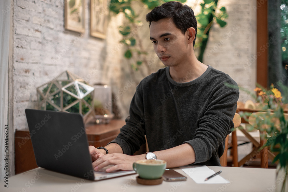 a man is working in his house and drinking coffee and using his mobile talking to his co worker a man is working in his house and drinking coffee and using his mobile talking to his co worker