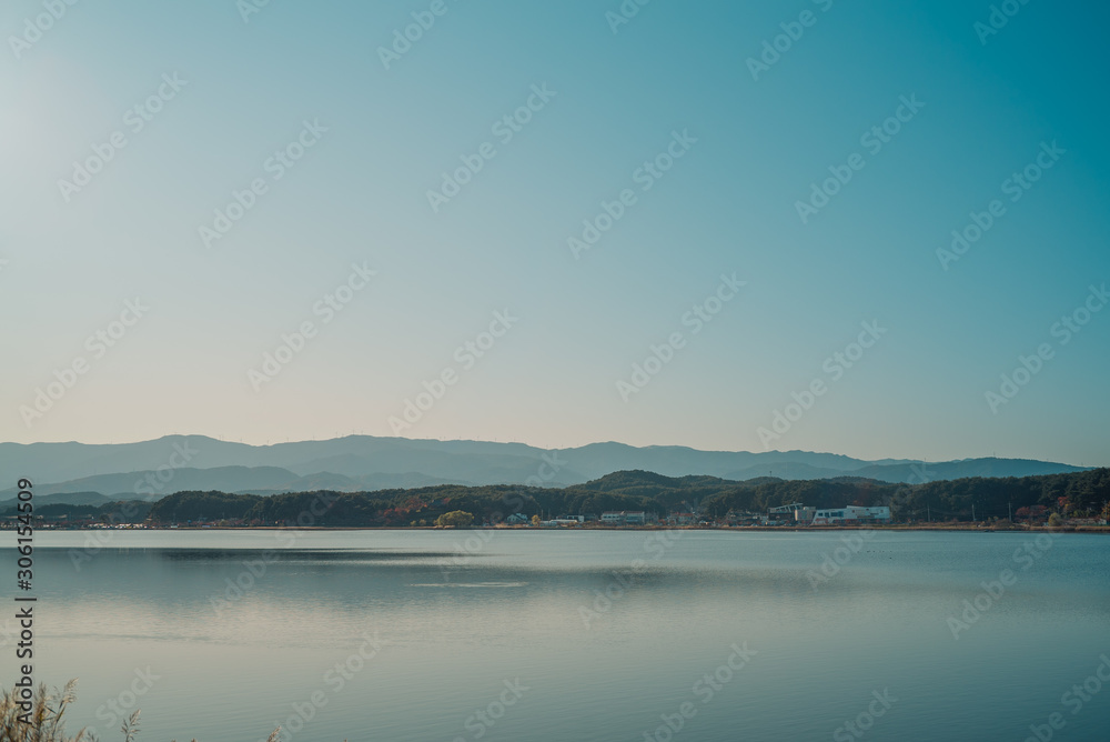 Calm surface of lake and long shot of layered mountains at Gangneung, South Korea