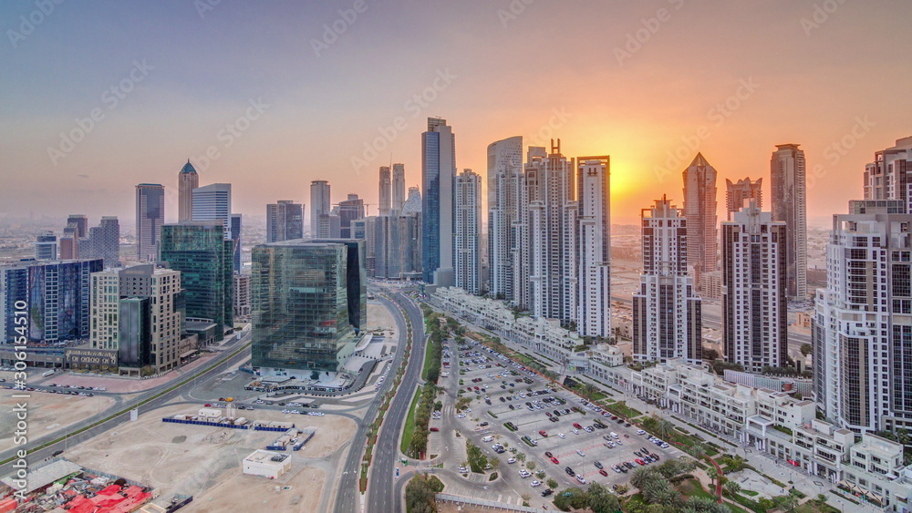 Luxury city with huge skyscrapers and roads with high traffic in Dubai city at sunset aerial timelapse