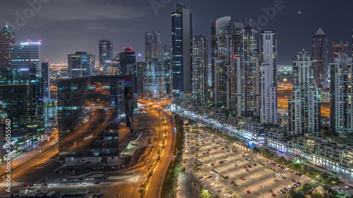 Modern residential and office complex with many towers aerial night timelapse at Business Bay, Dubai, UAE.