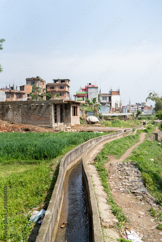 A canal stretches its way past Nepali houses