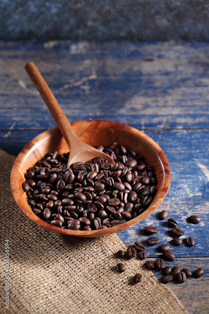Coffee beans in wooden cup on rustic wooden table with a blank space for a text, Coffee in cup on loft background Coffee beans in wooden cup on rustic wooden table with a blank space for a text, Coffee in cup on loft background