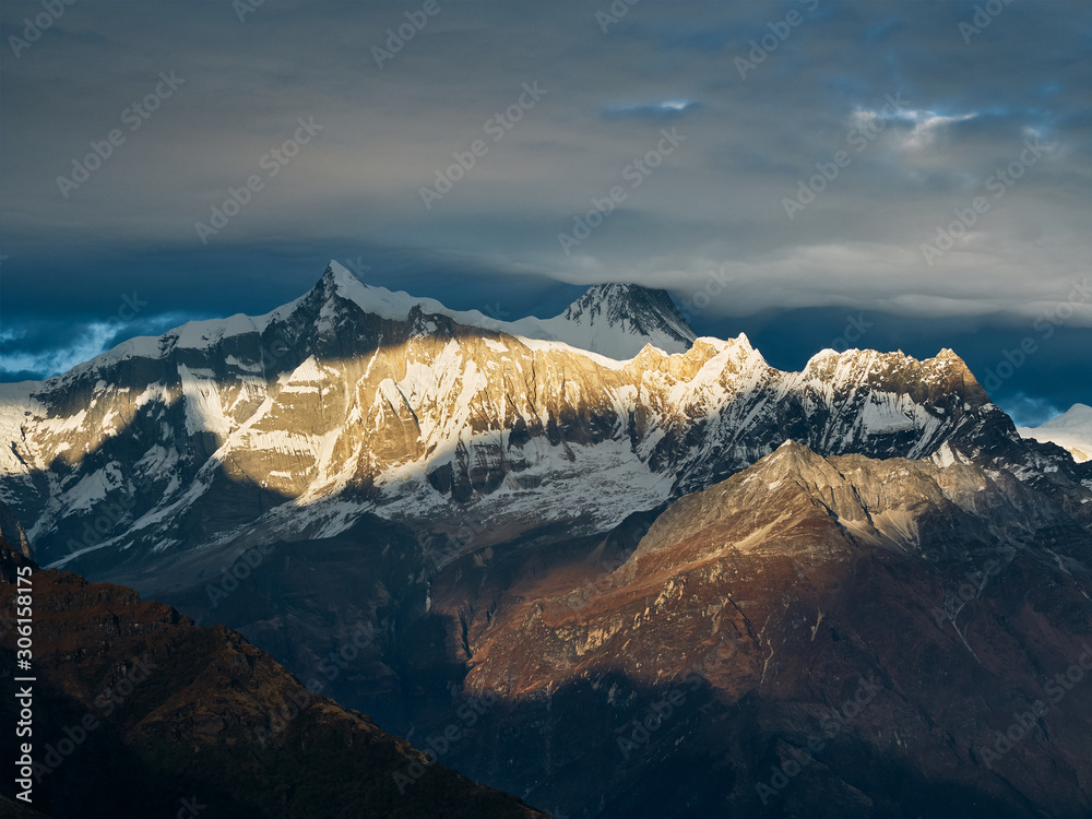 Sunset overlooking the majestic Himalayan peaks - Annapurna IV and Annapurna II, covered with clouds illuminated by the sunset