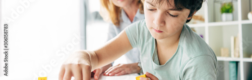 panoramic shot of kid with dyslexia sitting at table