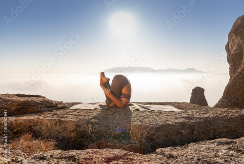 girl practices yoga in the mountains