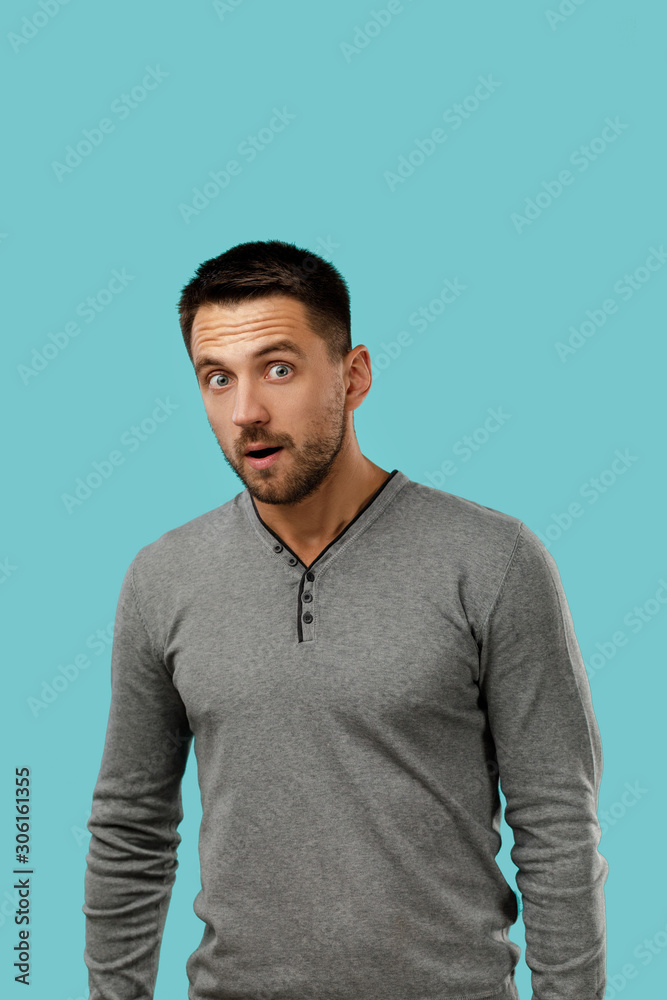 Portrait of young surprised handsome bearded man with shocked facial expression on blue background. is it really Portrait of young surprised handsome bearded man with shocked facial expression on blue background. is it really