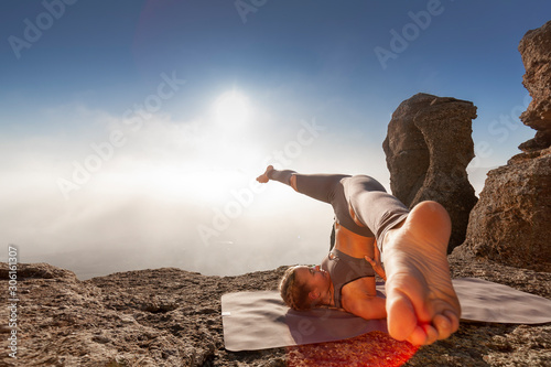girl practices yoga in the mountains
