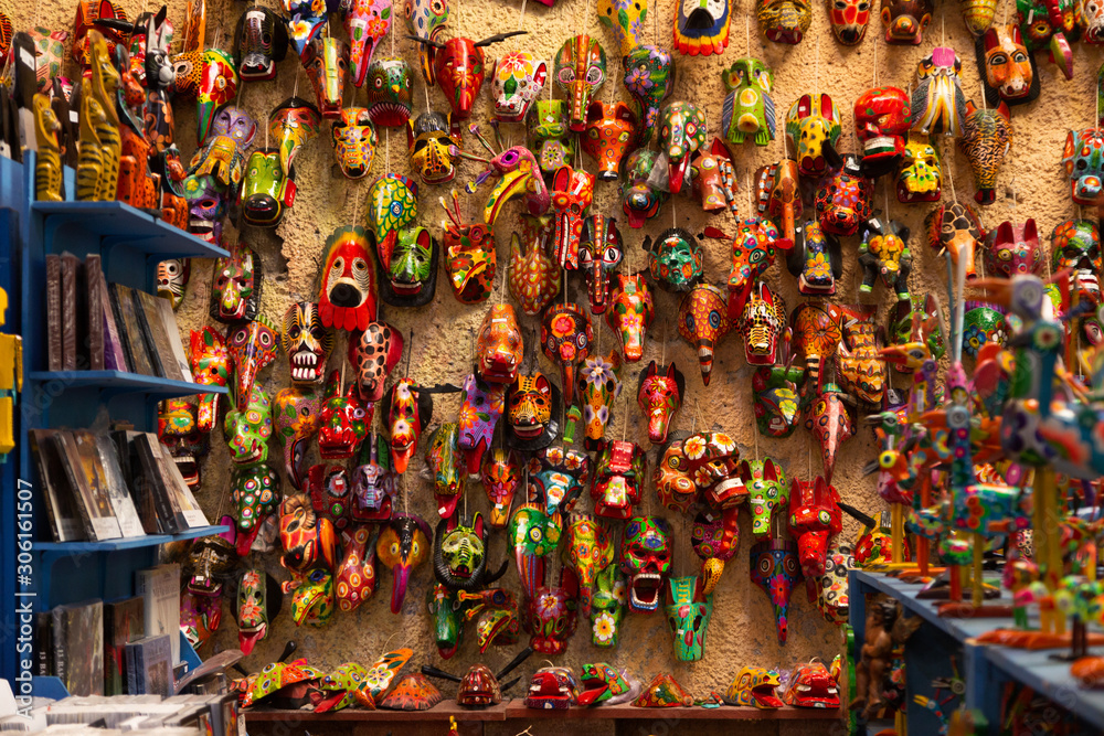 wall full of hand-painted colored masks - craft market in Antigua Guatemala - traditional colors of Guatemala