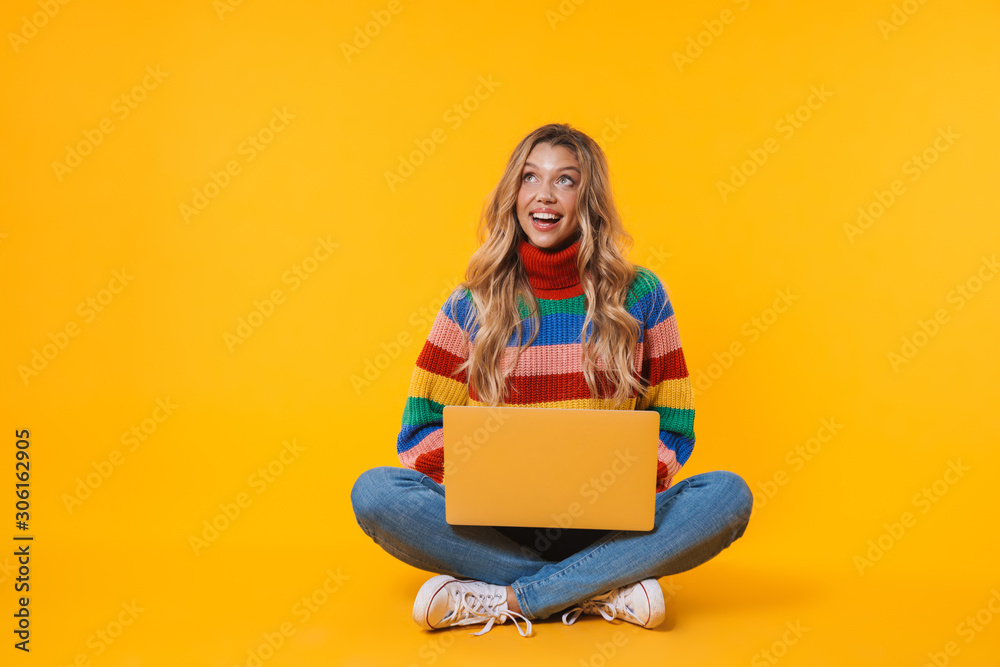 Naklejka premium Image of blonde woman using laptop computer while sitting on floor