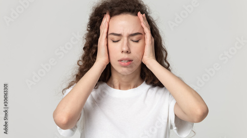 Obraz na płótnie Stressed millennial girl touch head suffering from migraine