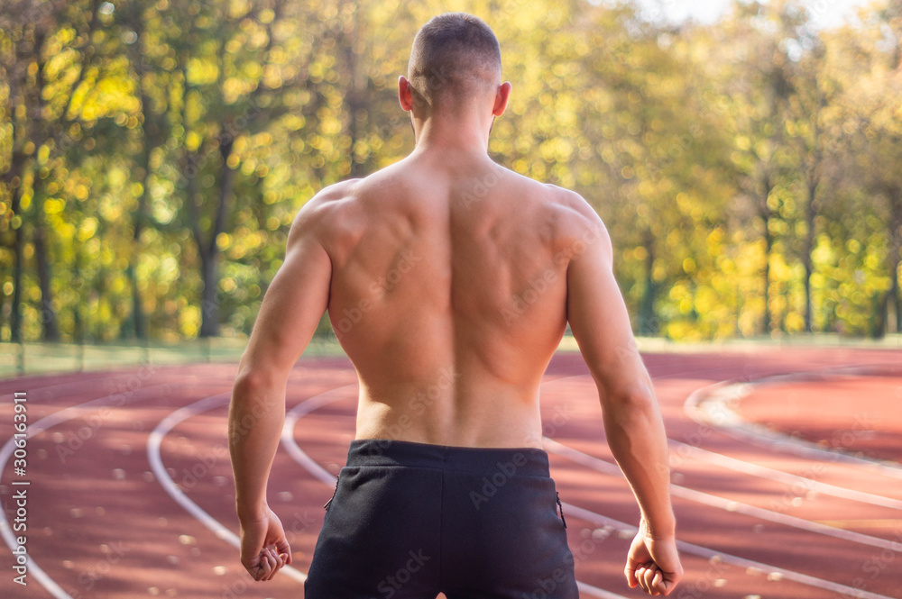 Male model with muscular fit and slim body at the city stadium. Male model with muscular fit and slim body at the city stadium.