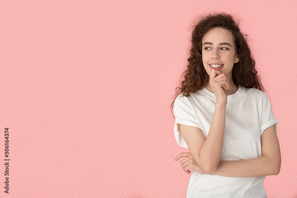 Smiling millennial girl thinking looking at blank copy space Smiling millennial girl thinking looking at blank copy space