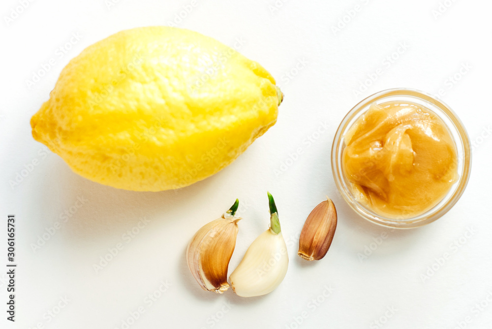 Lemon, honey and garlic on a white background. Immunity strengthening and virus protection Lemon, honey and garlic on a white background. Immunity strengthening and virus protection
