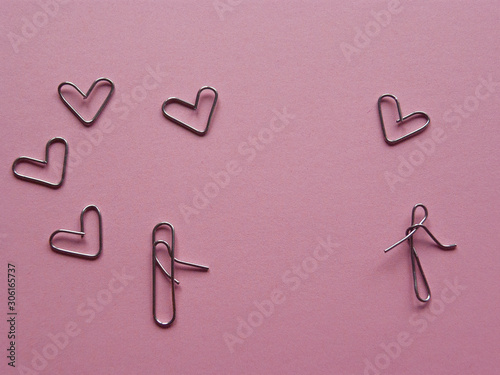meeting of lovers .installation of paper clips on a pink background.
