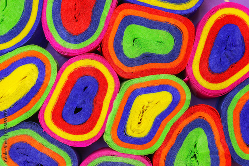 Close up coils of colorful crepe paper bunting of red, orange, yellow, green, blue and pink to make an abstract background