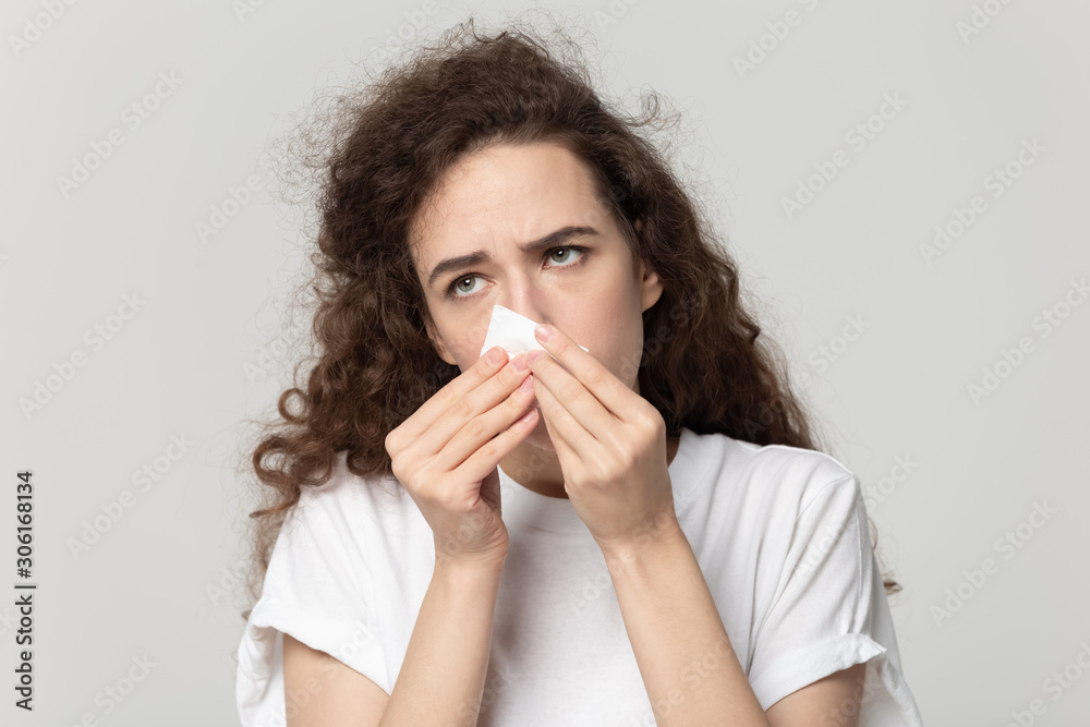 Sick young woman use tissue blowing runny nose Sick young woman use tissue blowing runny nose