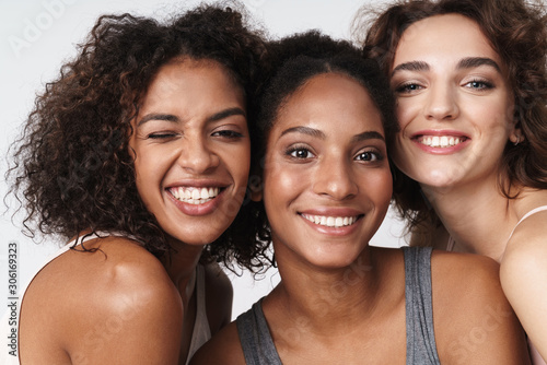 Portrait of delighted multiracial women standing together and smiling
