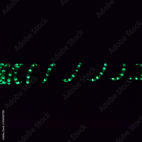 Spiral green led lights isolated on black background with copy space