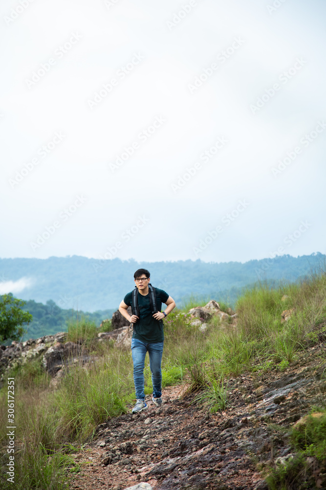 Fototapeta premium Young hiking man with backpack walking outdoor alone into the wild.