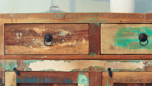 A part of old wooden multi-colored cupboard with drawers and two doors as background
