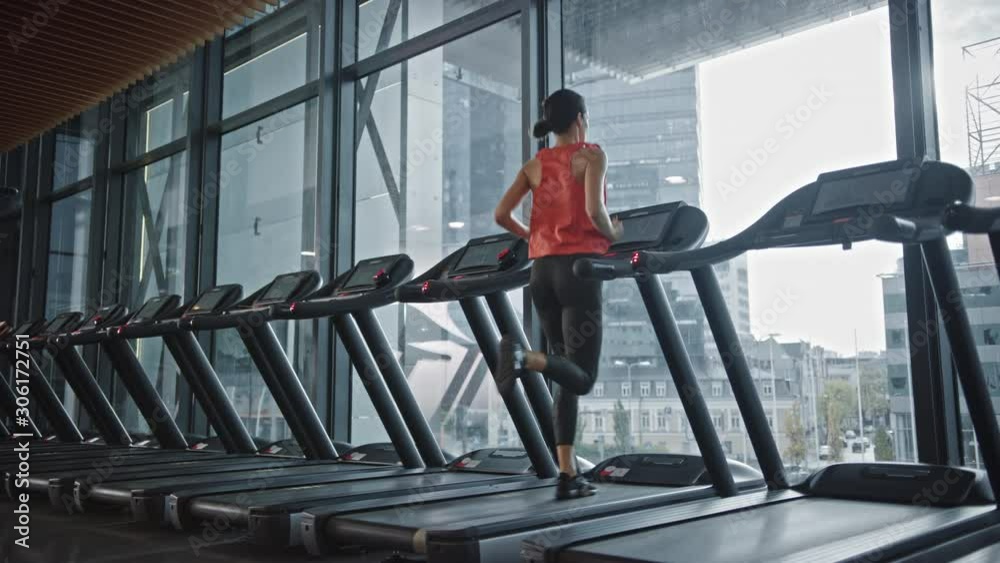 Beautiful Athletic Sports Woman Running on a Treadmill
