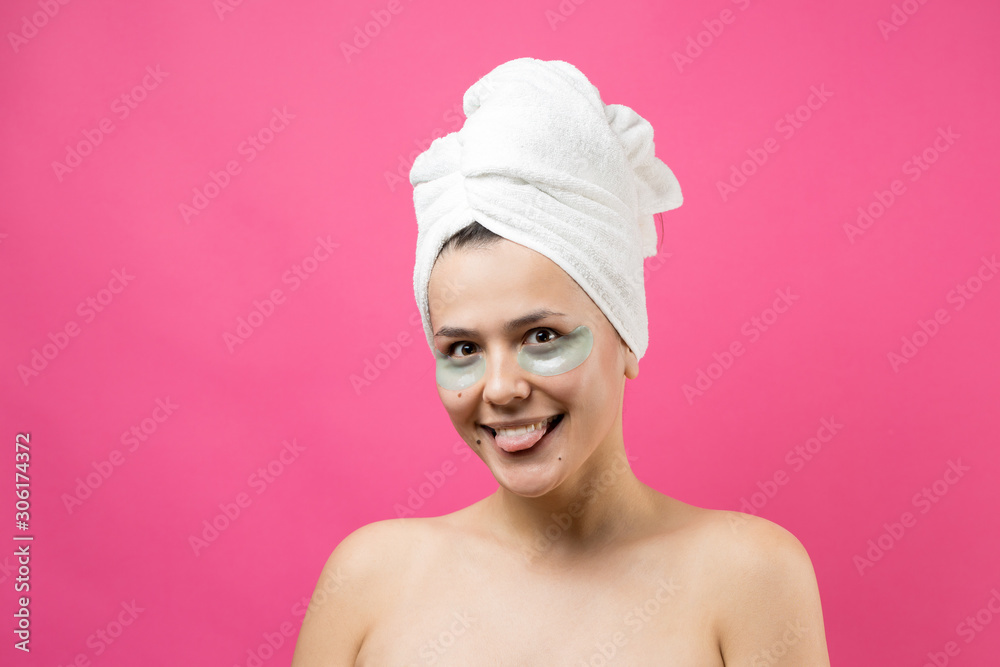 Young beautiful girl in a white towel on his head wears collagen gel patches under her eyes. Mask under eyes treatment face. Young beautiful girl in a white towel on his head wears collagen gel patches under her eyes. Mask under eyes treatment face.