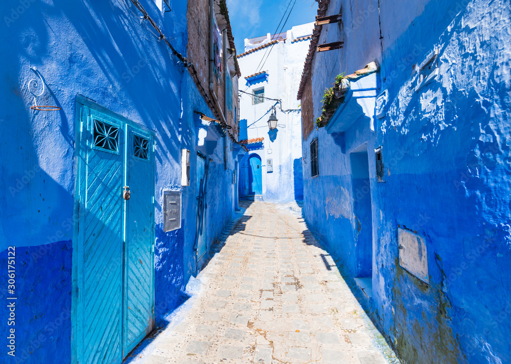 Blue walls of Chefchaouen street in Morocco with bright light