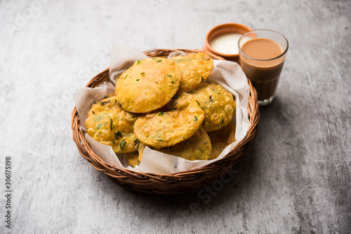 Methi Poori or Puri made using Fresh fenugreek leaves missed with wheat flour, by making small pancake size shapes deep fried in oil, served with tea photo