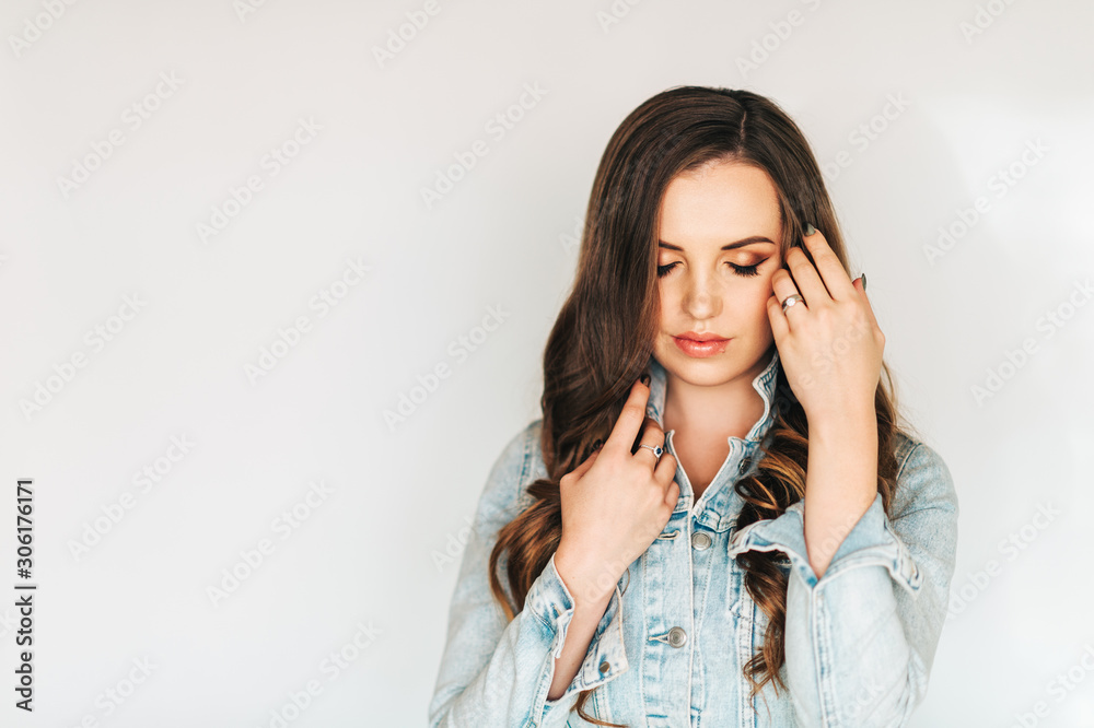 Portrait of young beautiful woman with long hairstyle, wearing blue denim jacket, eyes closed Portrait of young beautiful woman with long hairstyle, wearing blue denim jacket, eyes closed