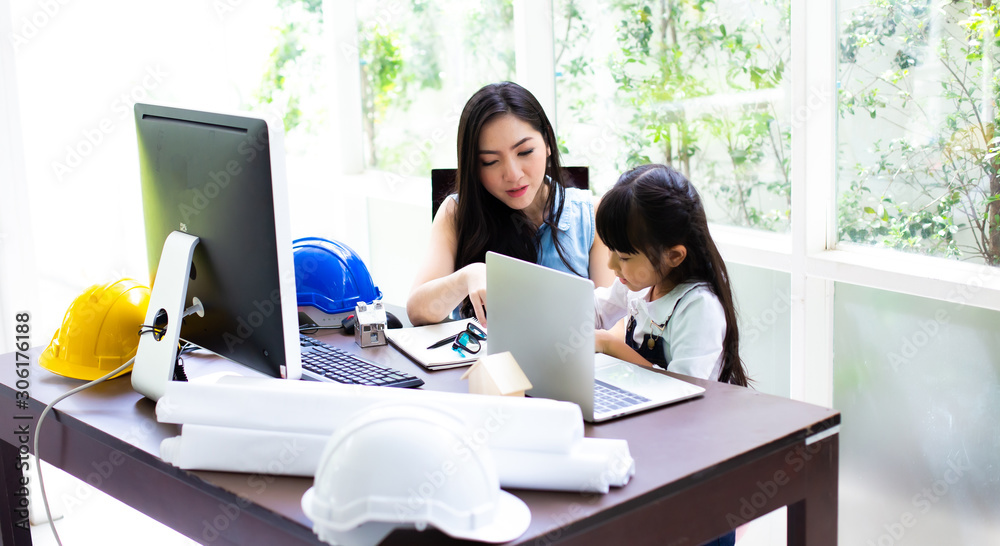 Businesswoman mother woman with daughter working at the computer. Mother working at home concept Businesswoman mother woman with daughter working at the computer. Mother working at home concept