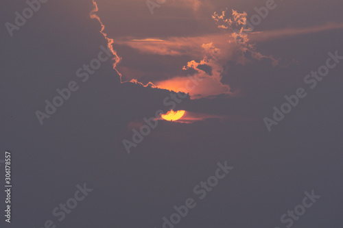Beautiful sun. The sun is hiding behind the clouds. Perspective.