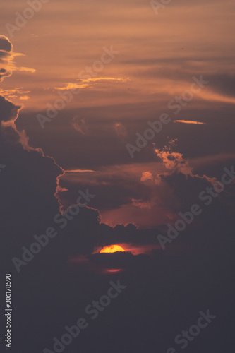 Beautiful sun. The sun is hiding behind the clouds. Perspective.