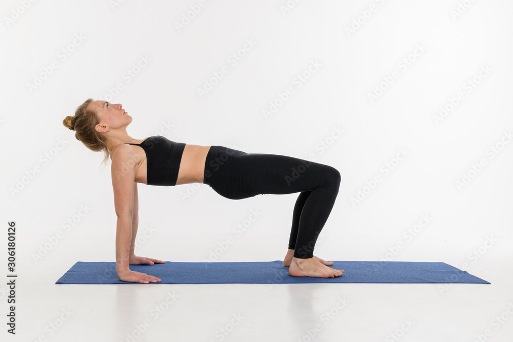 Sporty attractive young woman doing yoga practice on white background.