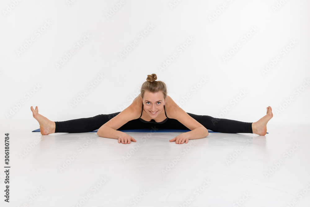 Sporty attractive young woman doing yoga practice on white background. Upavistha Konasana.