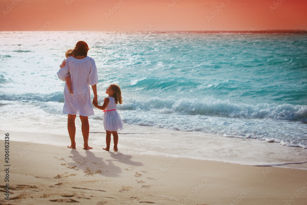 Mother with little girls looking at sunset on tropical beach Mother with little girls looking at sunset on tropical beach