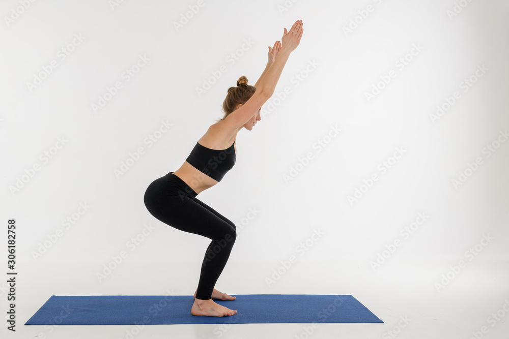 Sporty attractive young woman doing yoga practice on white background. Kursiasana.