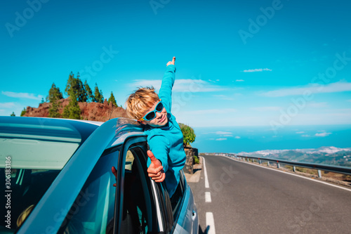 happy little boy enjoy travel by car on road in nature