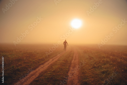 Health and fitness concept photo. Alone runner train in orange autumn morning nature