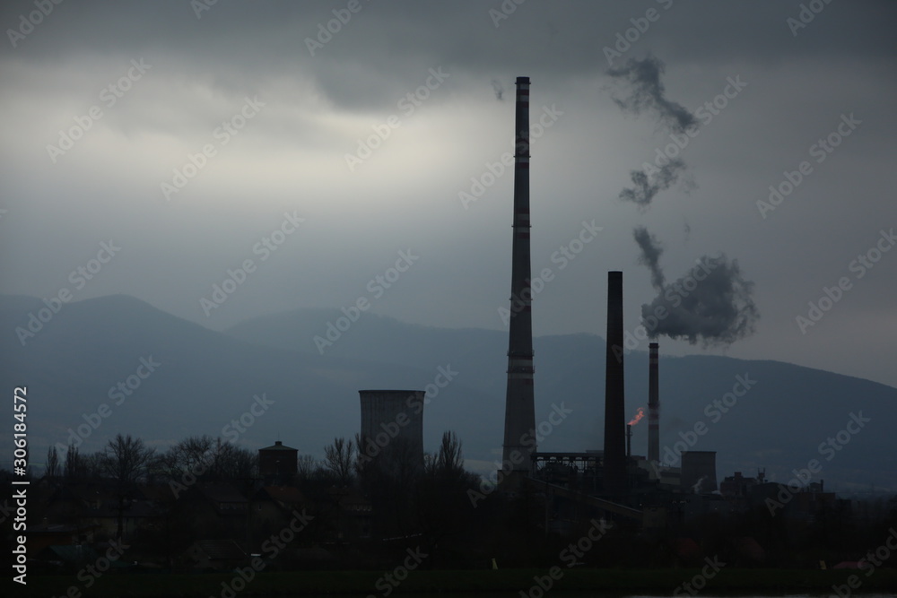 Smog hell - sunrise.  View from afar the city and a factory chimney with lots of smoke and smog.  Europe, landscape Slovakia, Novaky. Chemical factory. Abstract. Global warming of the earth.