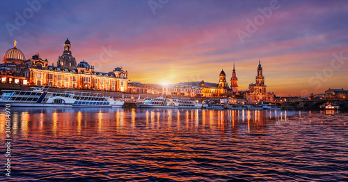 Wonderful colorful sunset over the famouse Old Town architecture in Dresden, with Elbe river embankment with reflections. Colorful sunset in Dresden, Saxony, Germany, Europe. Creative image.