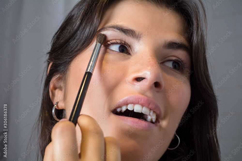 Woman applying make up in bathroom. Woman applying make up in bathroom.
