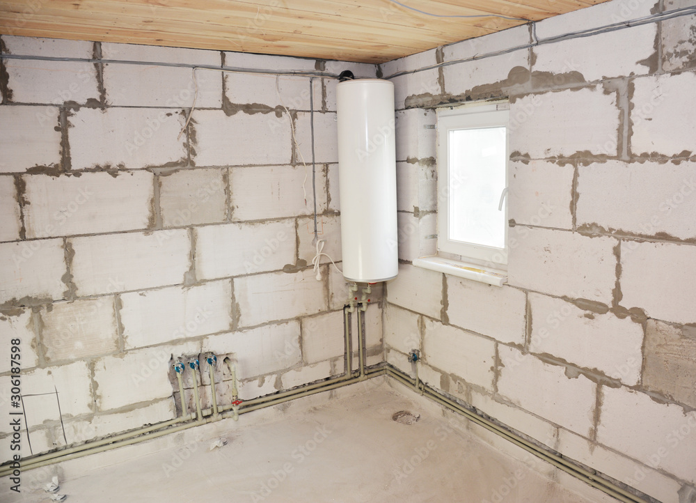 Installing electric boiler and groove or trench cut for water pipeline and electric wire in the bathroom wall