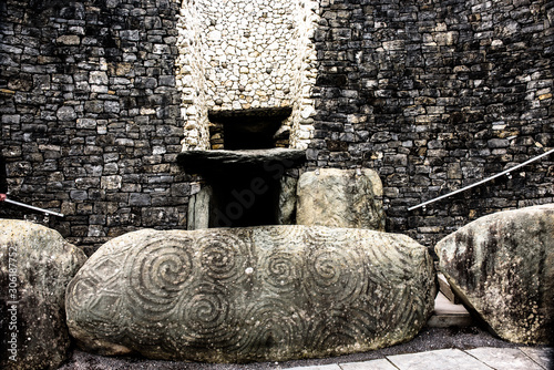 Entry of New grange passage tomb and stones carved with tri spiral pattern photo