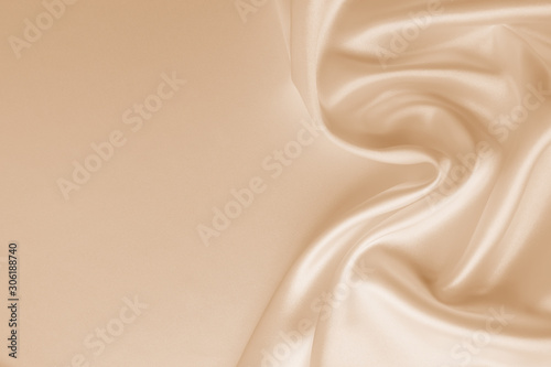 Beautiful smooth elegant wavy beige / light brown satin silk luxury cloth fabric texture, abstract background design. Copy space. Card or banner