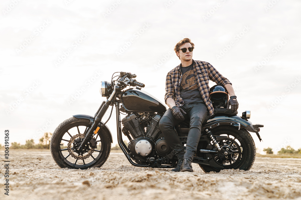 Man biker on bike outdoors at the desert field.