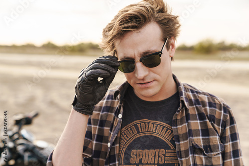 Biker outdoors at the desert field wearing sunglasses.