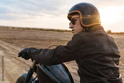 Young man biker on bike outdoors at the desert field. © Drobot Dean